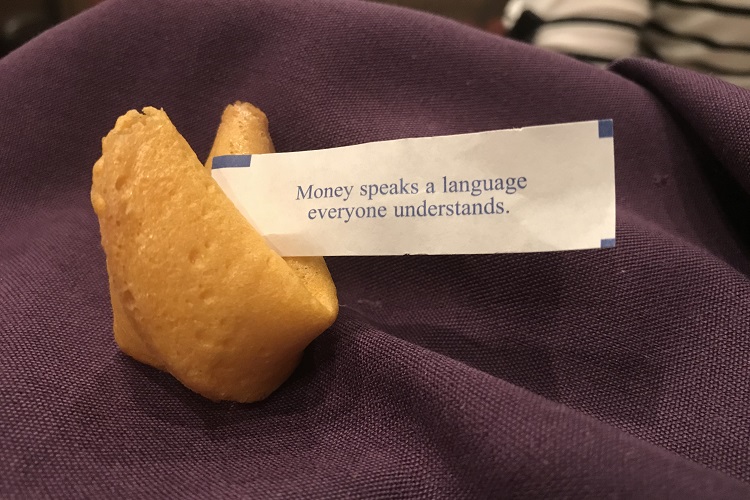 Fortune cookie on purple napkin that says 