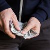 Is Your Salary an Unhealthy Addiction? close up of addict or drug dealer hands with money
