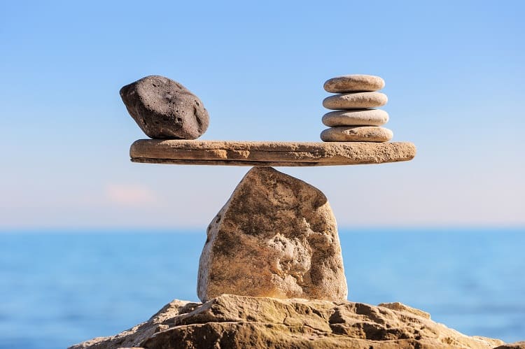 Rocks balanced on rocks. Growth stocks vs. dividend stocks. 