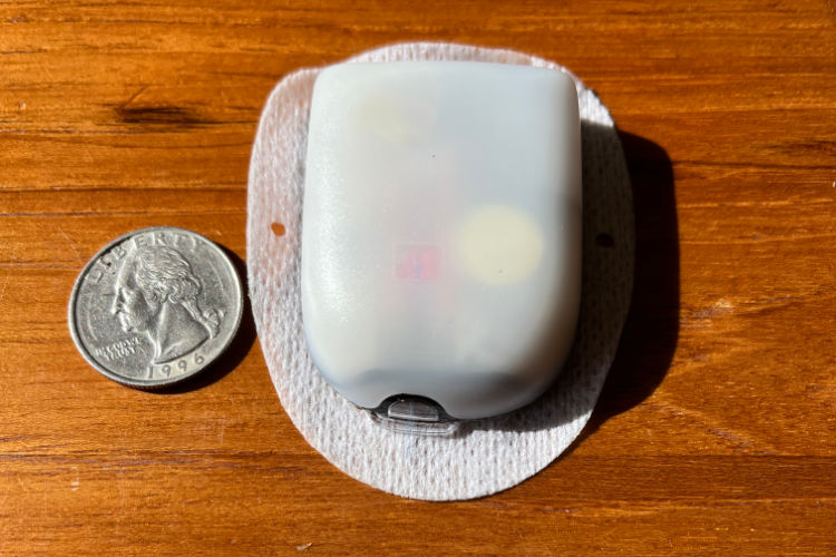Photo of the Omnipod Dash insulin pump next to a US quarter coin for size comparison. List of diabetes stocks to celebrate Diabetes Awareness Month.