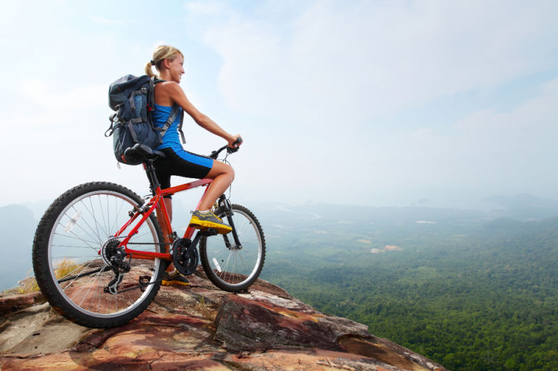 Woman on mountain at top of a peak. Learn how to start saving for retirement at 40, 50, or beyond. 